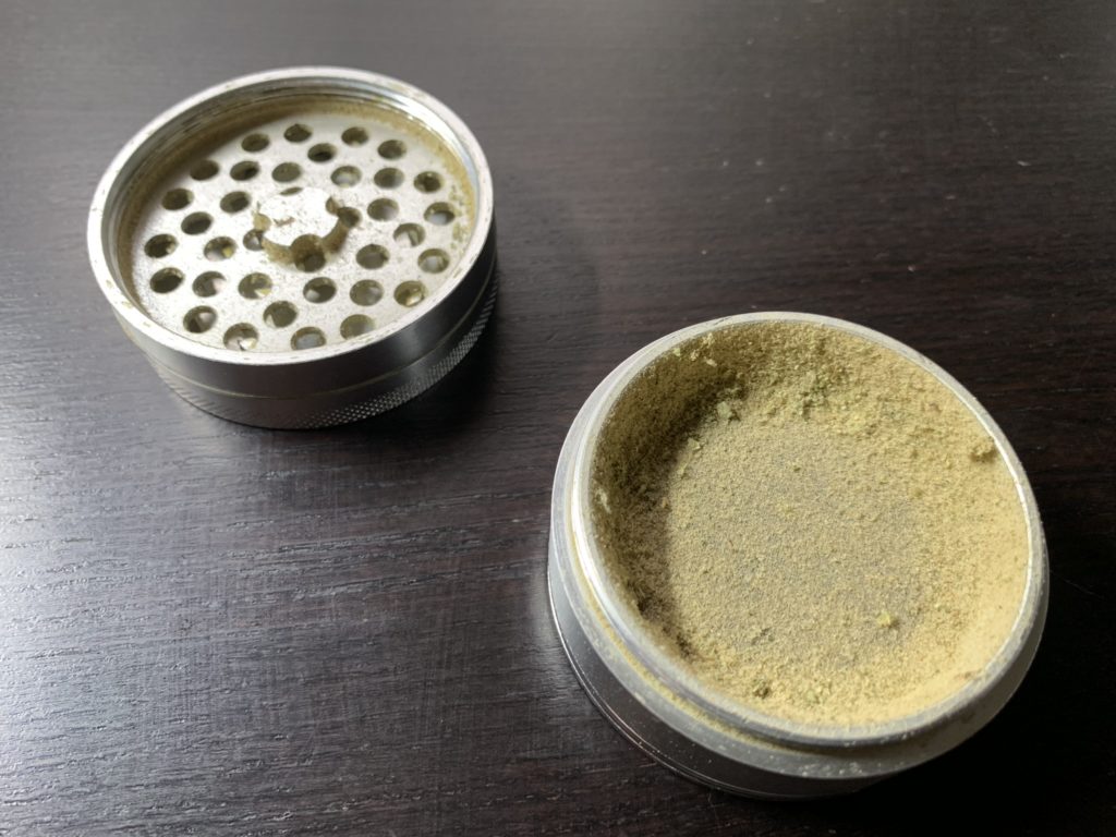 Picture of Cali Crusher Grinder with built up assorted kief.