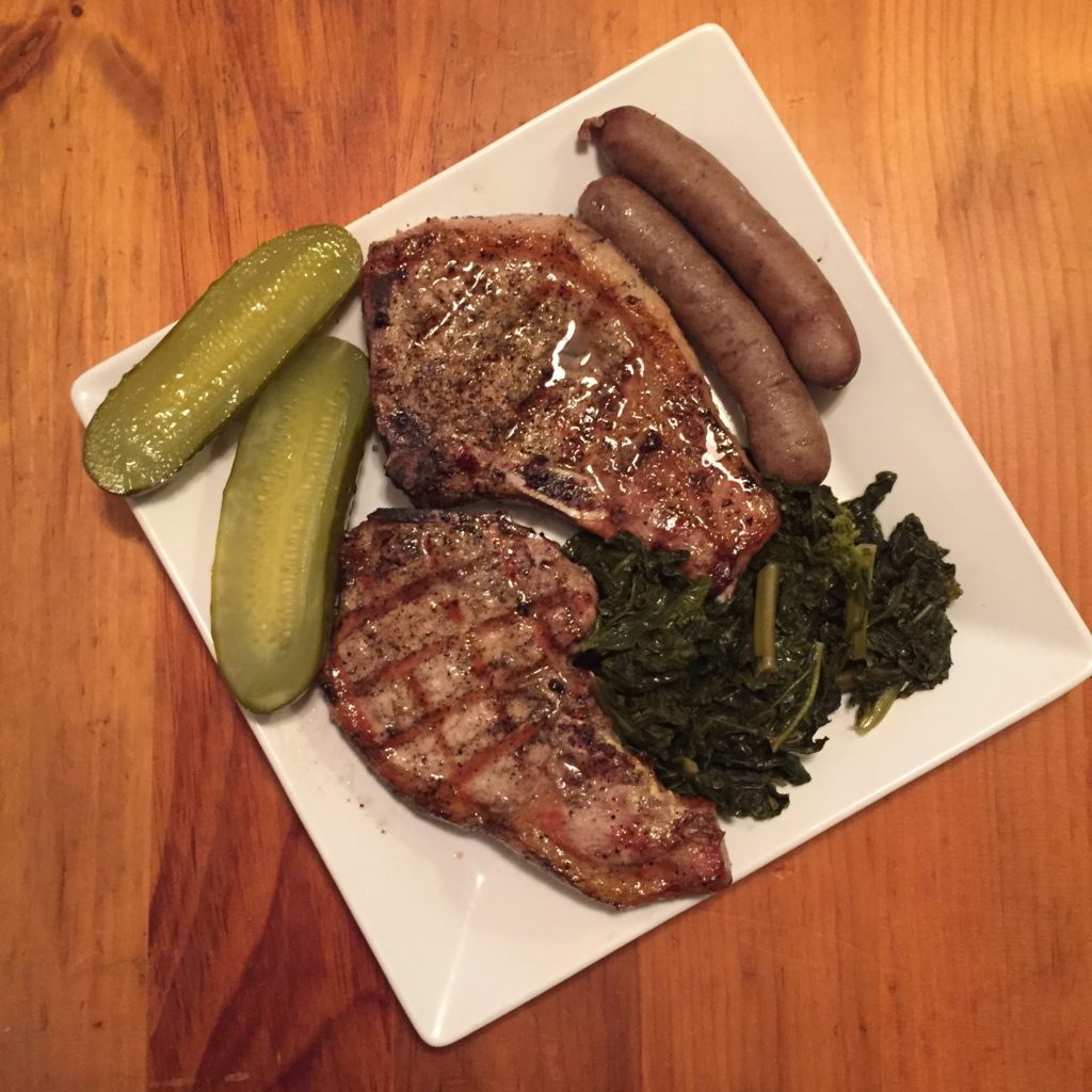 Grilled pork chops, braised kale, sausages and pickles.