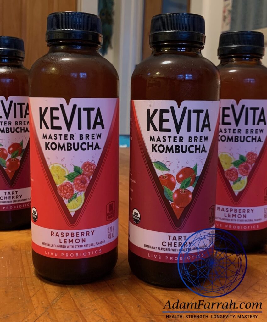 Chilled bottles of kombucha tea on a wooden table.